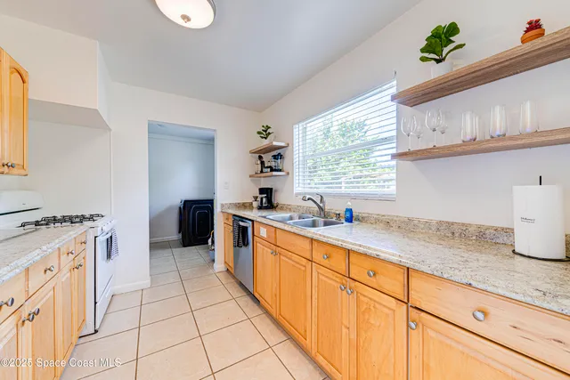 a kitchen with a sink a stove cabinets and a window