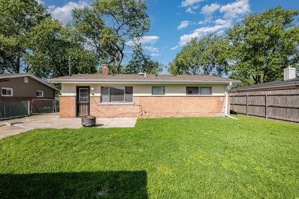 a view of a house with a yard and sitting area