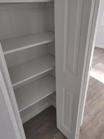 a view of walk in closet with empty racks