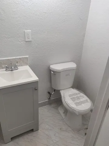 a white toilet sitting next to a bathroom sink