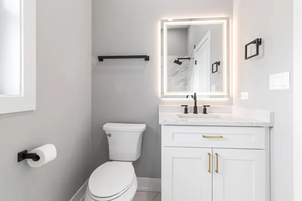 a bathroom with a toilet sink vanity and mirror