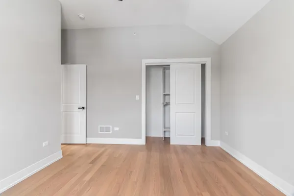 an empty room with wooden floor and door