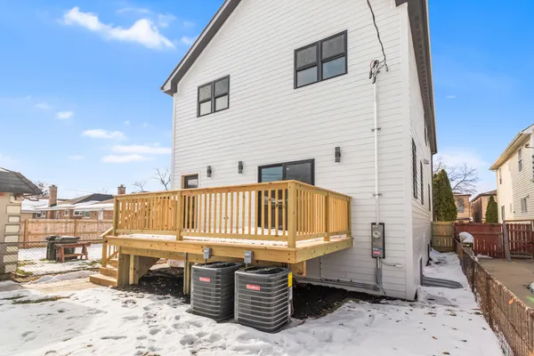 a view of a roof deck with table and chairs a barbeque with wooden floor and fence