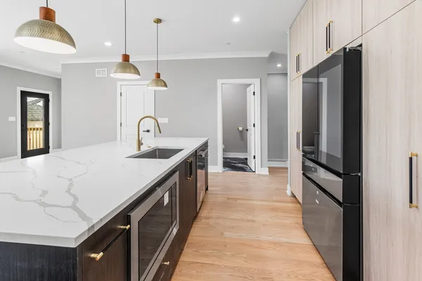 a kitchen with kitchen island granite countertop a sink and refrigerator