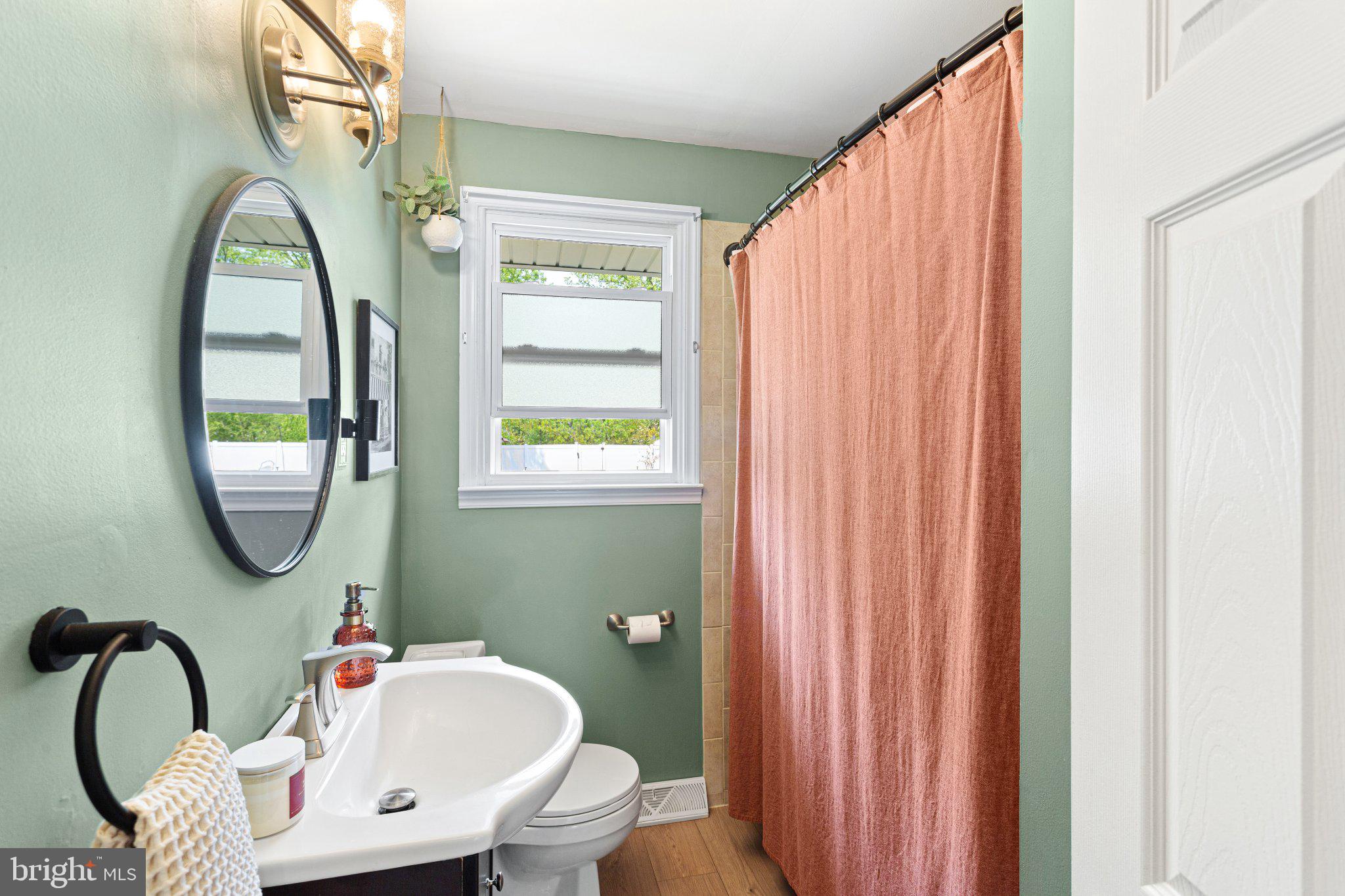 725 West 3rd Avenue Runnemede, NJ 08078 - Photo 12 of 35 a bathroom with a sink a mirror a toilet and a window