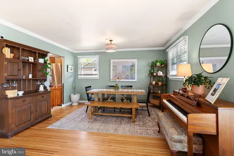 a living room with furniture a piano and a bookshelf