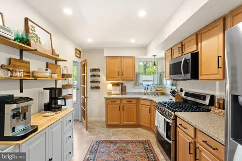 a kitchen with stainless steel appliances granite countertop a stove a sink and a refrigerator