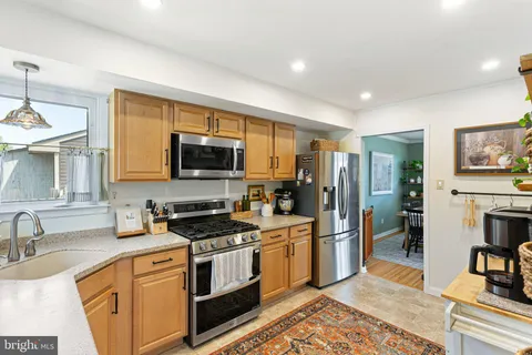 a kitchen with stainless steel appliances granite countertop a refrigerator stove and sink