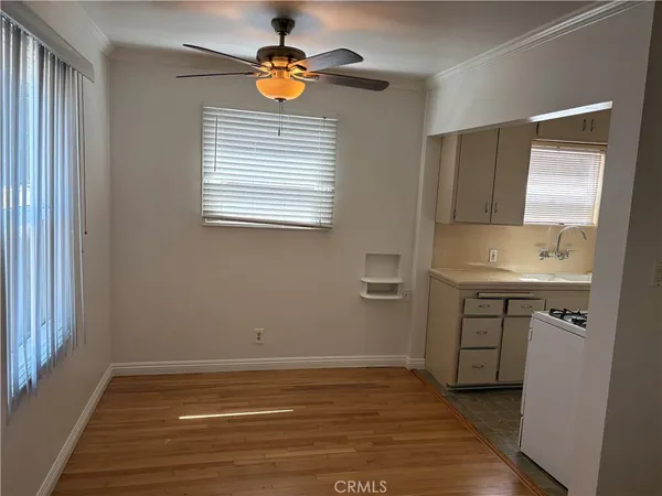 a view of an empty room with a window and wooden floor