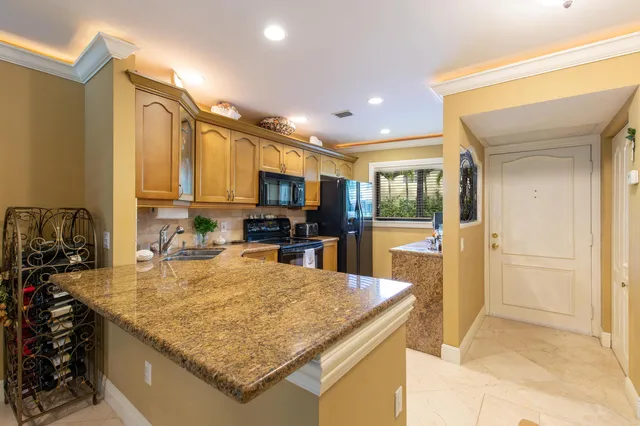 a kitchen with stainless steel appliances granite countertop a sink refrigerator and cabinets