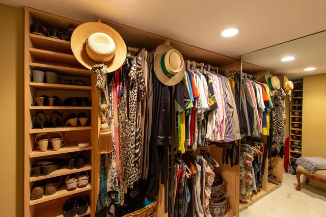 a view of walk in closet with clothes and shoes