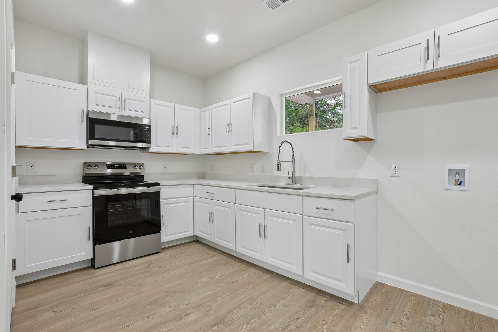 210 Flint Ridge Street Bastrop, TX 78602 - Photo 11 of 40 a kitchen with granite countertop white cabinets and white appliances