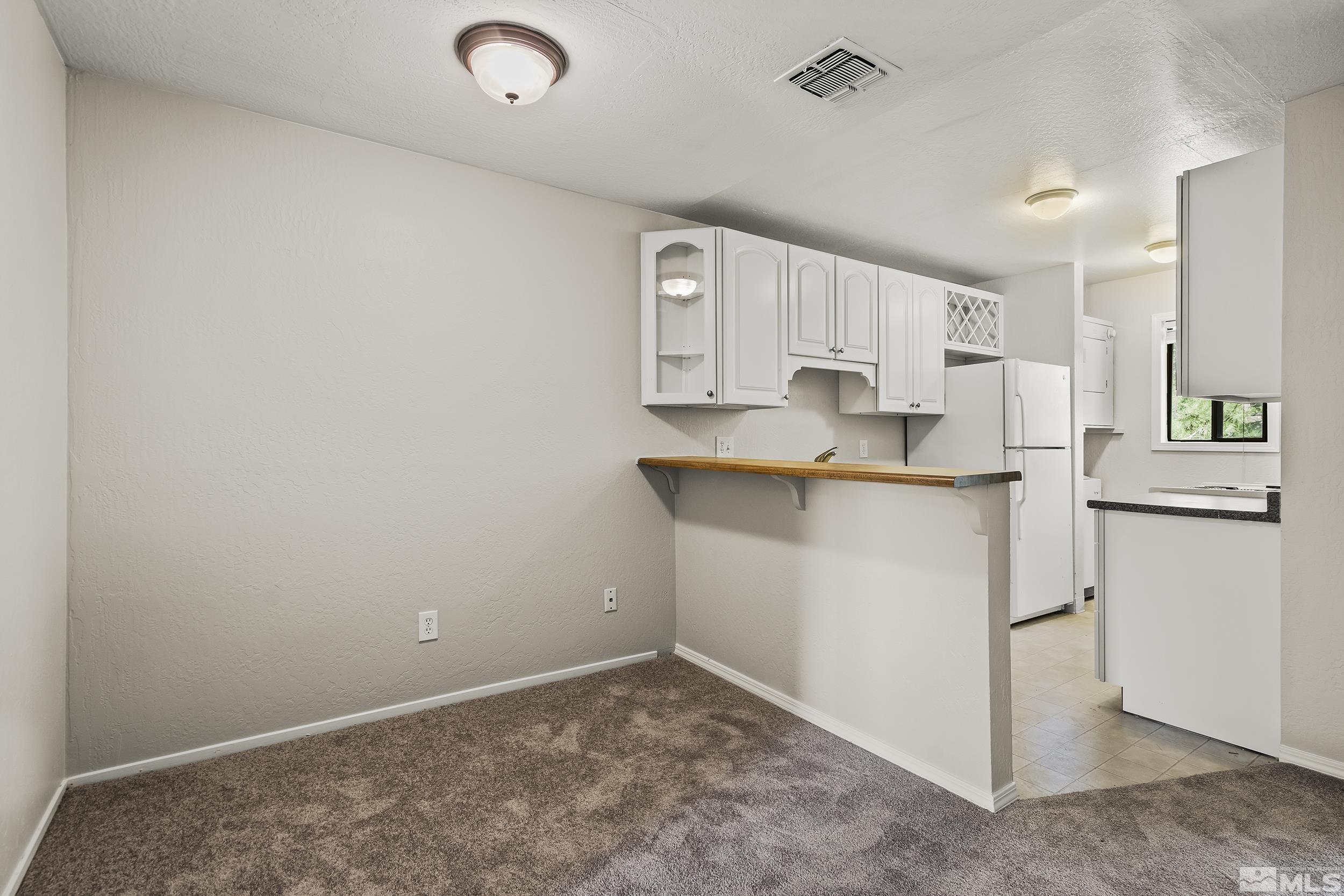 4694 Rio Poco Road Reno, NV 89502 - Photo 6 of 19 a kitchen with kitchen island a sink a stove a refrigerator and white cabinets