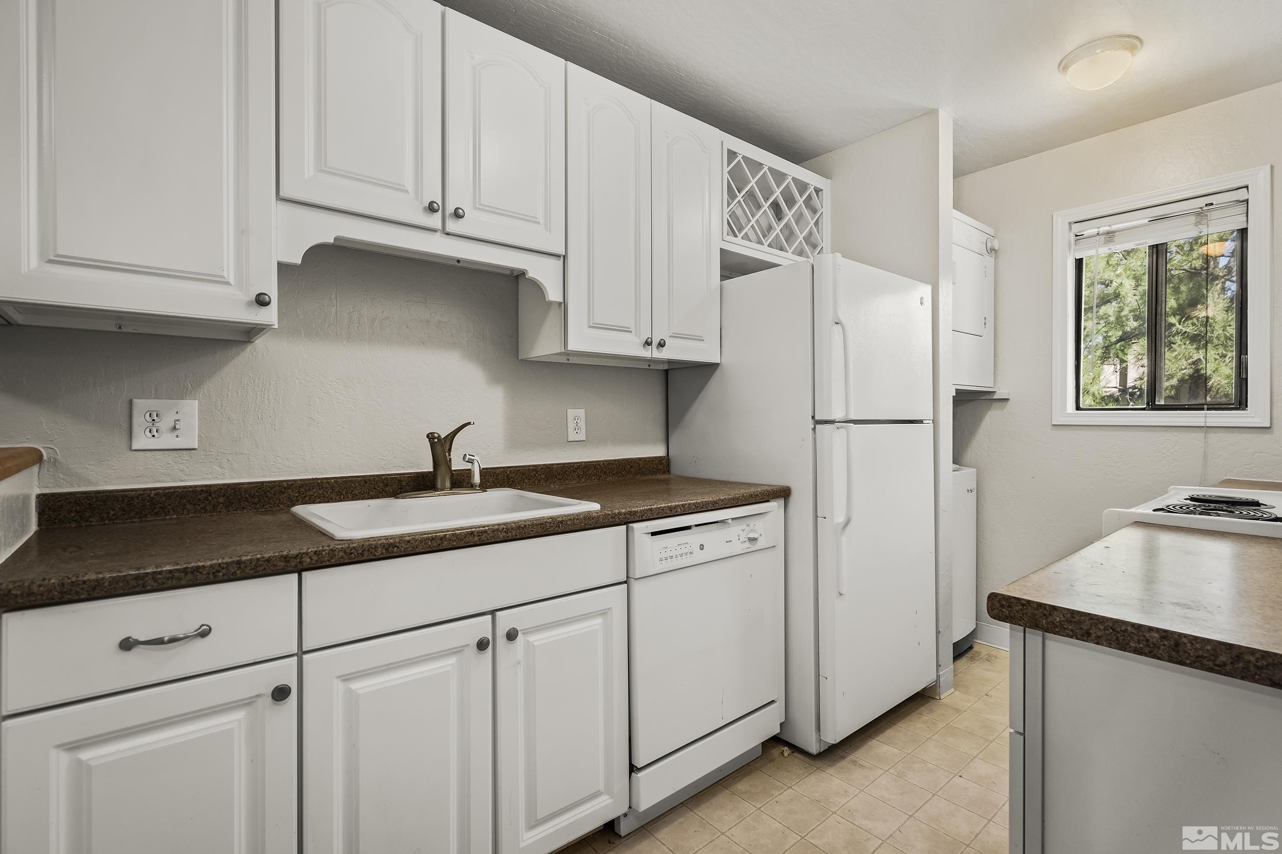 4694 Rio Poco Road Reno, NV 89502 - Photo 8 of 19 a kitchen with granite countertop white cabinets and refrigerator