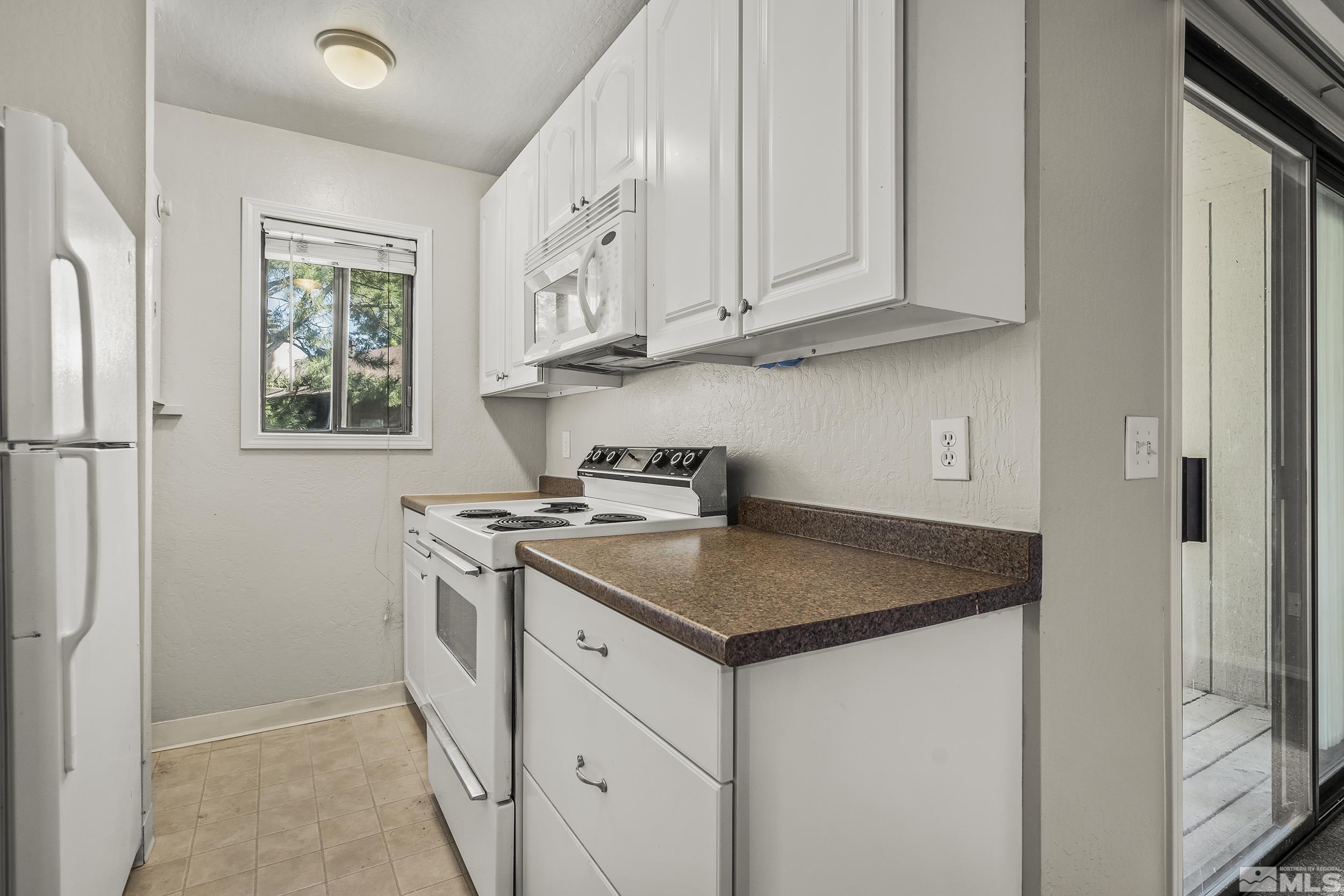 4694 Rio Poco Road Reno, NV 89502 - Photo 9 of 19 a kitchen with stainless steel appliances granite countertop a sink stove and refrigerator