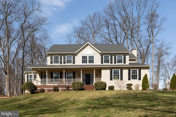 a front view of a house with a garden and trees