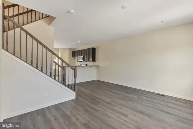 a view of staircase with wooden floor and white walls