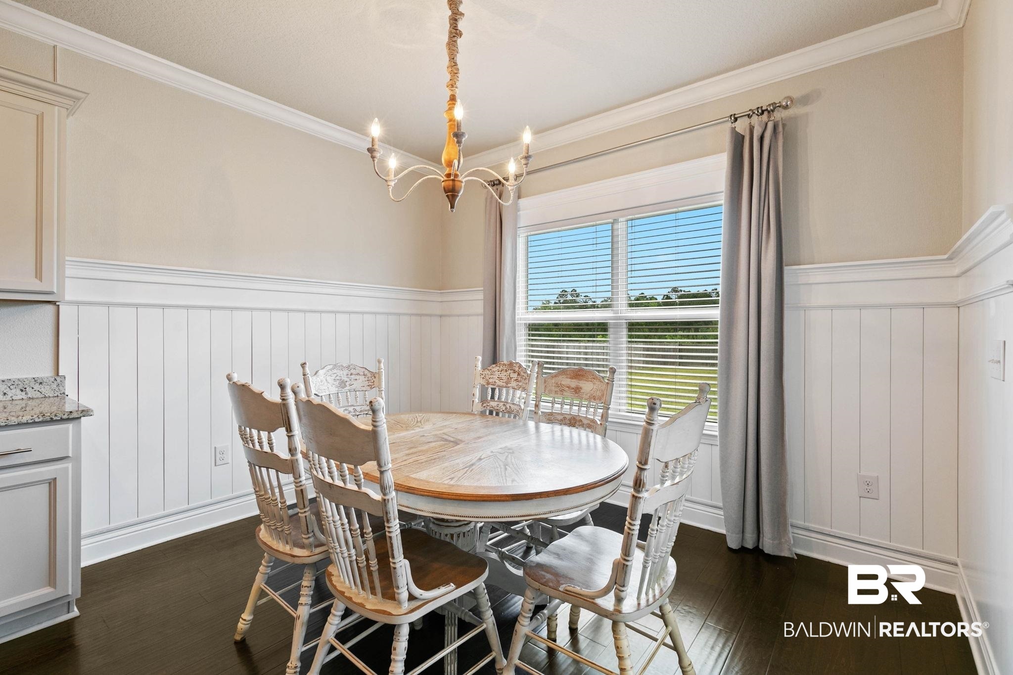 31187 Spoonbill Road Daphne, AL 36527 - Photo 19 of 85 Dining area with dark wood-finish flooring, white beadboard wainscoting, and crown molding