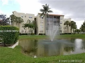 a backyard of a house with table and chairs plants and large tree