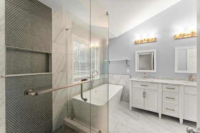 a spacious bathroom with double vanity a mirror a lamp and a bathtub