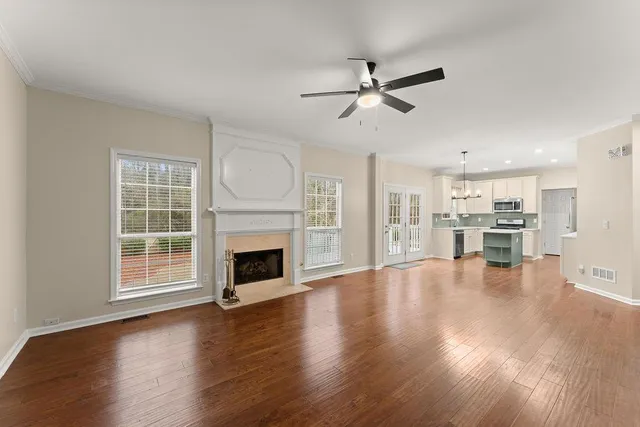 a view of a livingroom with fireplace wooden floor and windows