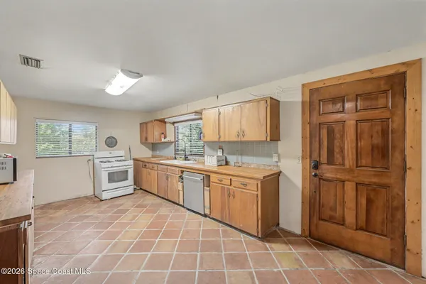 a large kitchen with stainless steel appliances granite countertop a stove a sink and a refrigerator