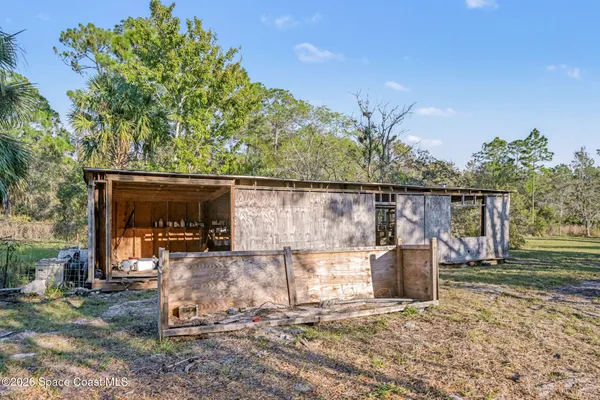 a view of a patio with table and chairs and potted plants with wooden fence