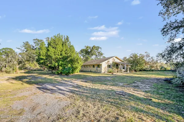 a front view of a house with a yard and trees