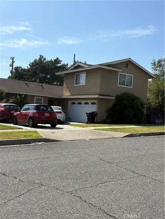 a front view of a house with cars parked