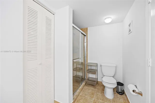 a white toilet sitting next to a shower