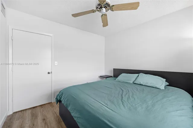 a bedroom with a bed and a chandelier fan