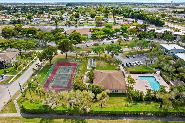 an aerial view of residential houses with outdoor space and lake view