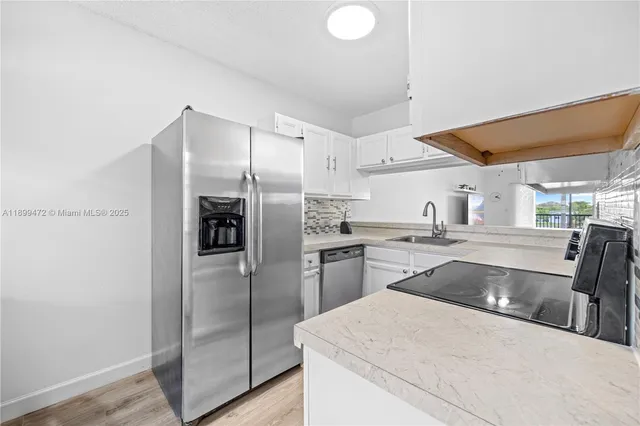 a kitchen with stainless steel appliances granite countertop a refrigerator and a sink