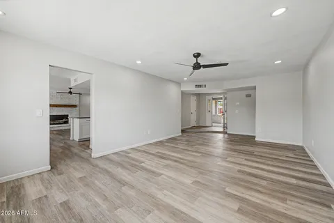 a view of empty room with wooden floor and ceiling fan
