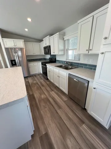 a large kitchen with kitchen island a stove a sink and a refrigerator