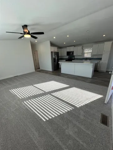 a kitchen with stainless steel appliances kitchen island granite countertop a stove a sink and a refrigerator