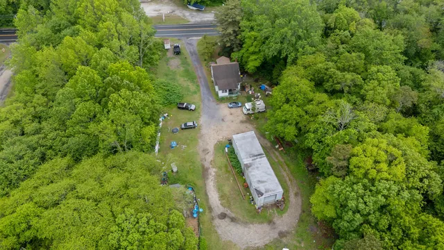an aerial view of residential house with outdoor space and trees all around