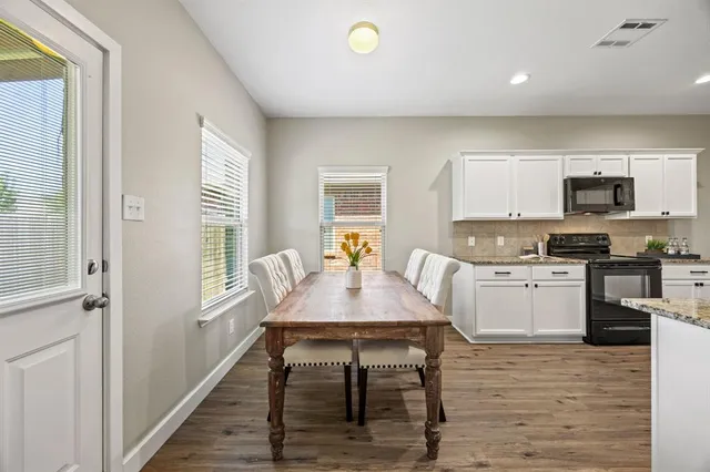 a kitchen with a table chairs a sink dishwasher window and cabinets