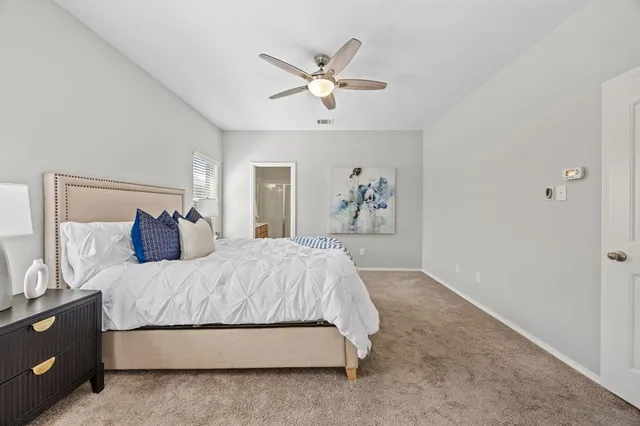 a bedroom with a large bed and a chandelier