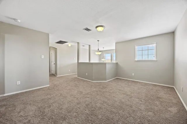 an empty room with a kitchen and windows