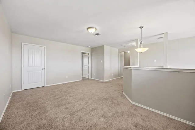 a view of an empty room with a kitchen