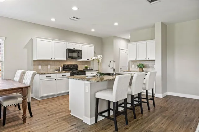 a kitchen with a dining table chairs and microwave
