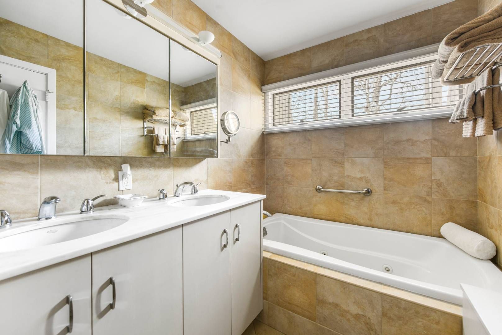 45 South Country Road Westhampton, NY 11977 - Photo 15 of 22 a bathroom with a granite countertop sink a mirror a bathtub and next to a window