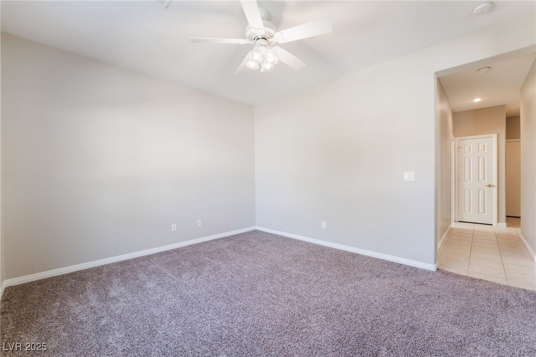 7857 Midnight Ride Street Las Vegas, NV 89131 - Photo 13 of 53 Unfurnished room featuring light carpet, baseboards, a ceiling fan, and a smoke detector