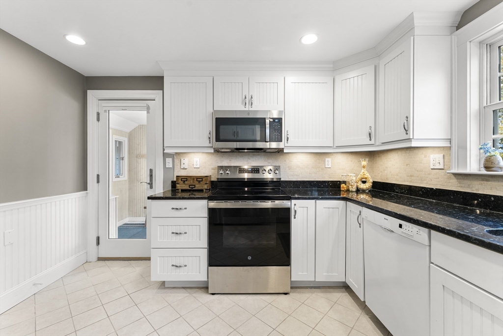 1052 Greendale Avenue Needham, MA 02492 - Photo 12 of 42 a kitchen with granite countertop white cabinets and stainless steel appliances