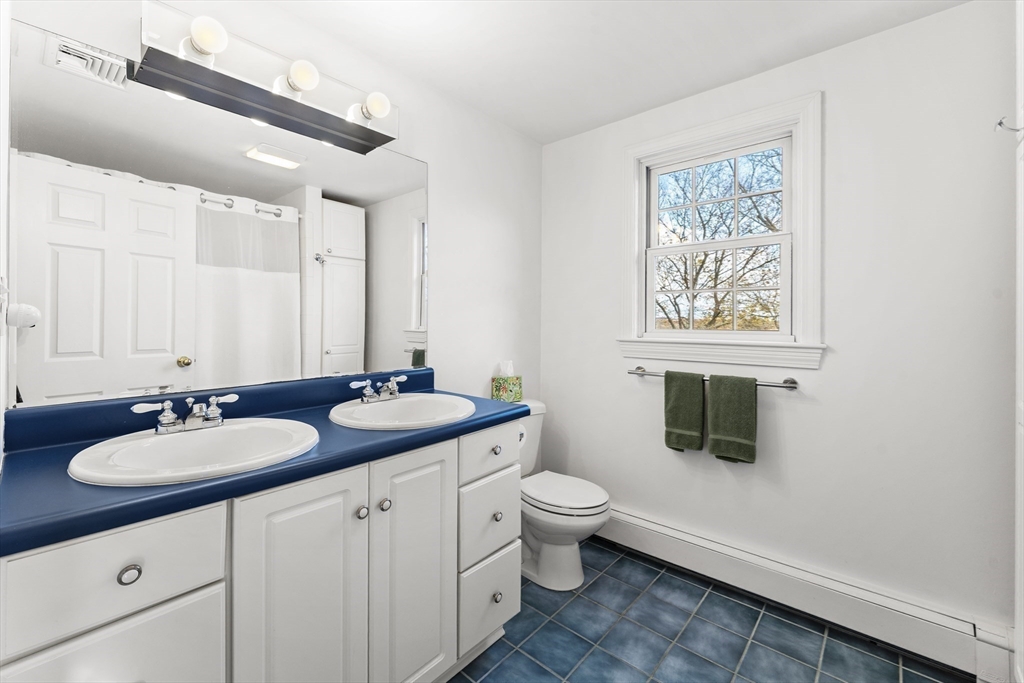 1052 Greendale Avenue Needham, MA 02492 - Photo 27 of 42 a bathroom with a granite countertop sink and a mirror