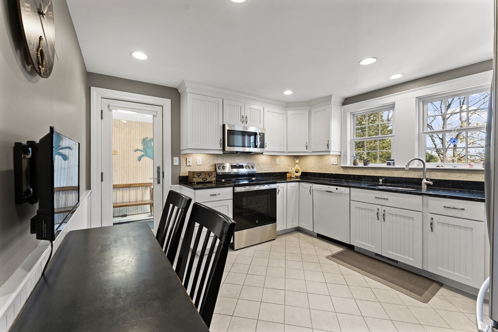 1052 Greendale Avenue Needham, MA 02492 - Photo 9 of 42 a kitchen with granite countertop a stove a sink a dining table and chairs