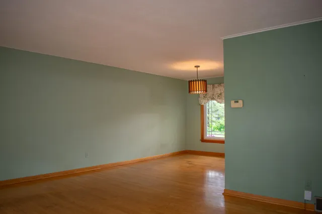 an empty room with wooden floor and a window