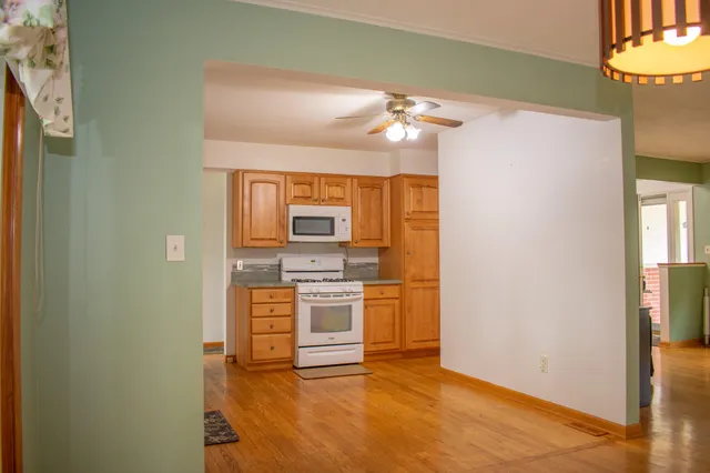 a kitchen with stainless steel appliances granite countertop white cabinets and a large window