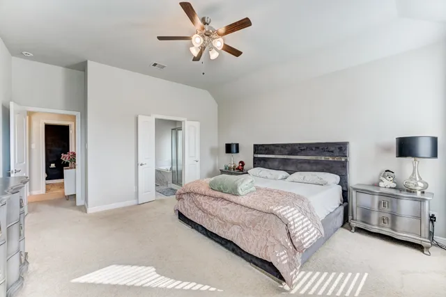 a bedroom with a large bed and a chandelier